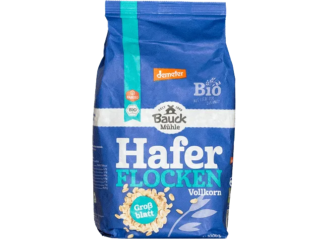 Blaues Vollkorn-Haferflockenpaket mit Markenaufdruck und Bio-Siegeln freigestellt vor neutralem Hintergrund platziert